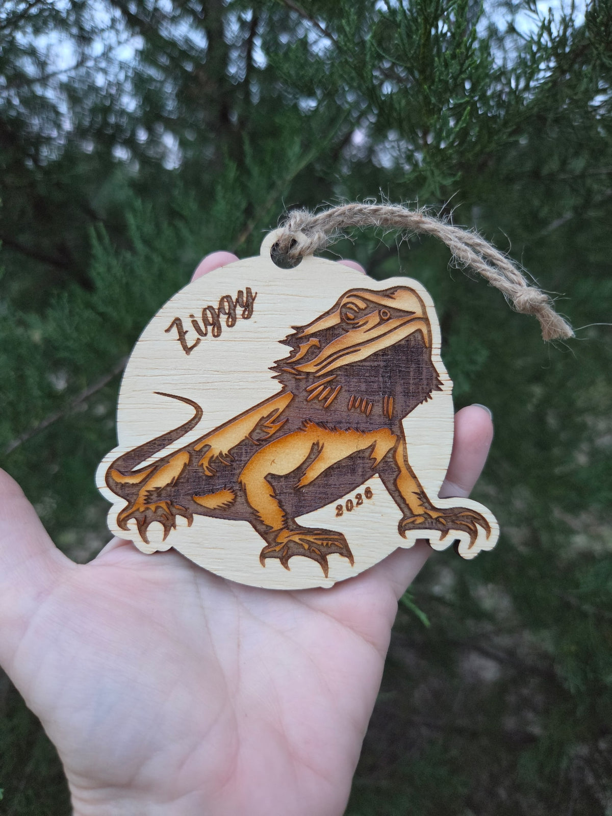 Bearded dragon ornament held in an open hand to show its size