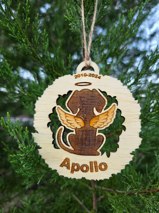 Wooden dog memorial ornament, a dog with angel wings, engraved Apollo and 2010-2024, on an evergreen