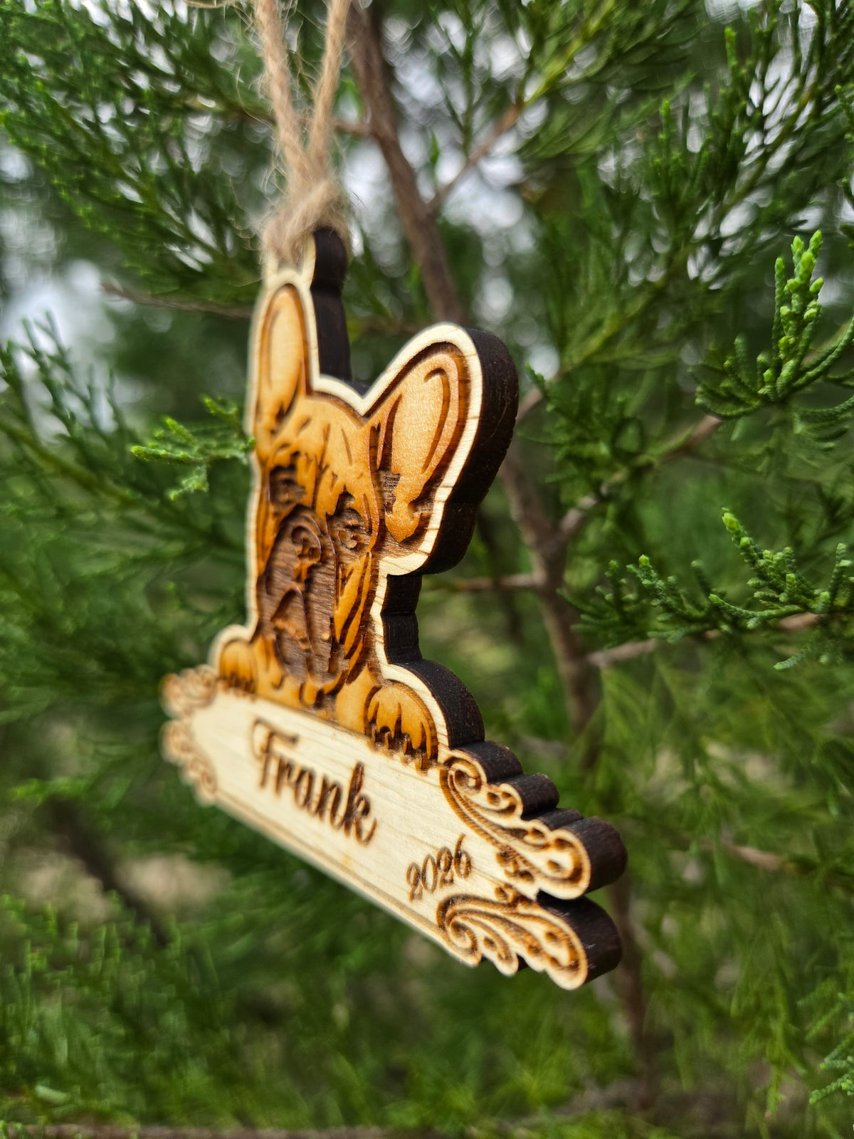 Side view of the French Bulldog ornament showing the thickness of the wood and its dark cut edges