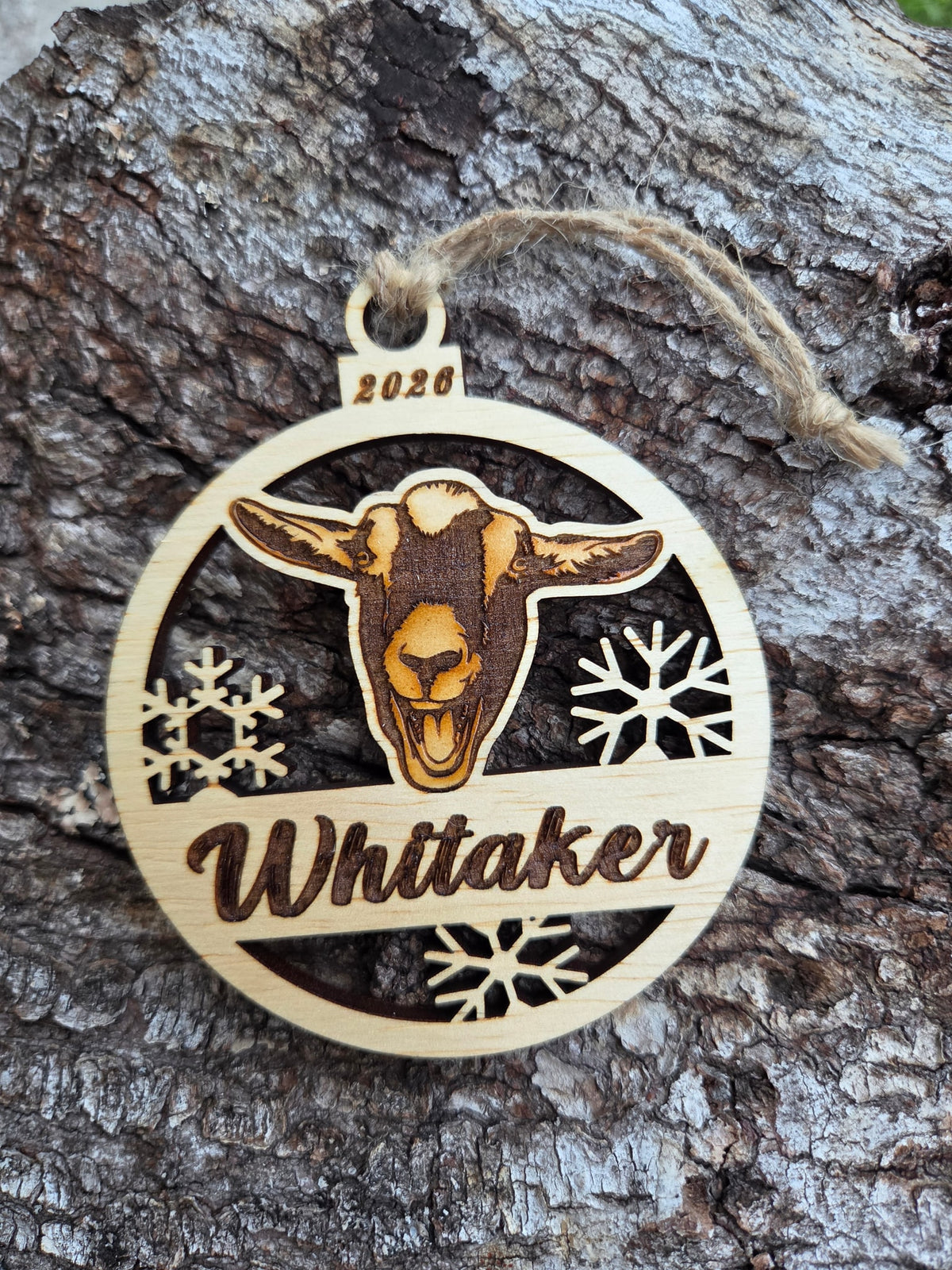 Wooden goat face and snowflakes ornament, front layer with a sample name and year engraved, shown without its colored back