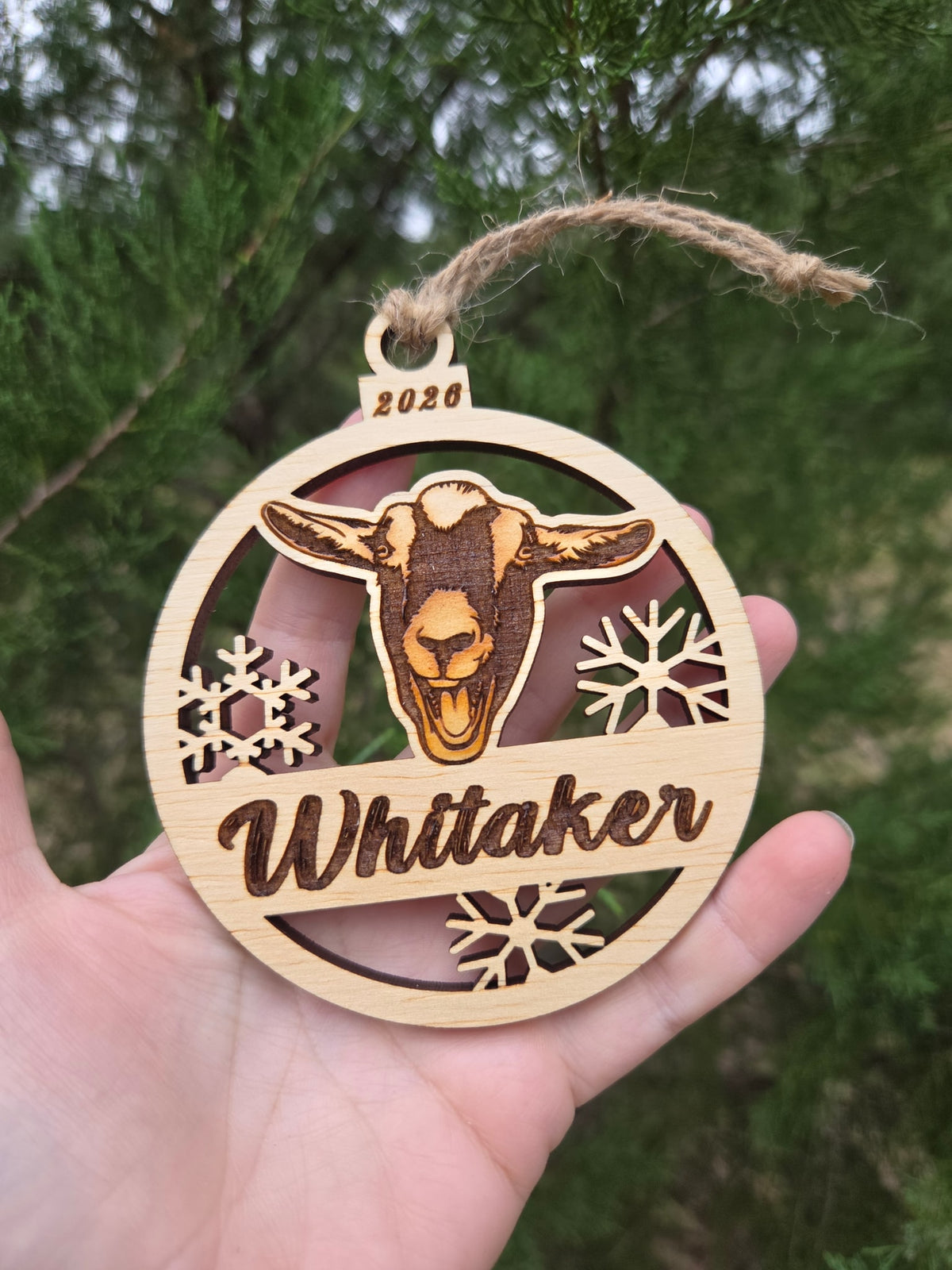 Goat face and snowflakes ornament held in an open hand to show its size