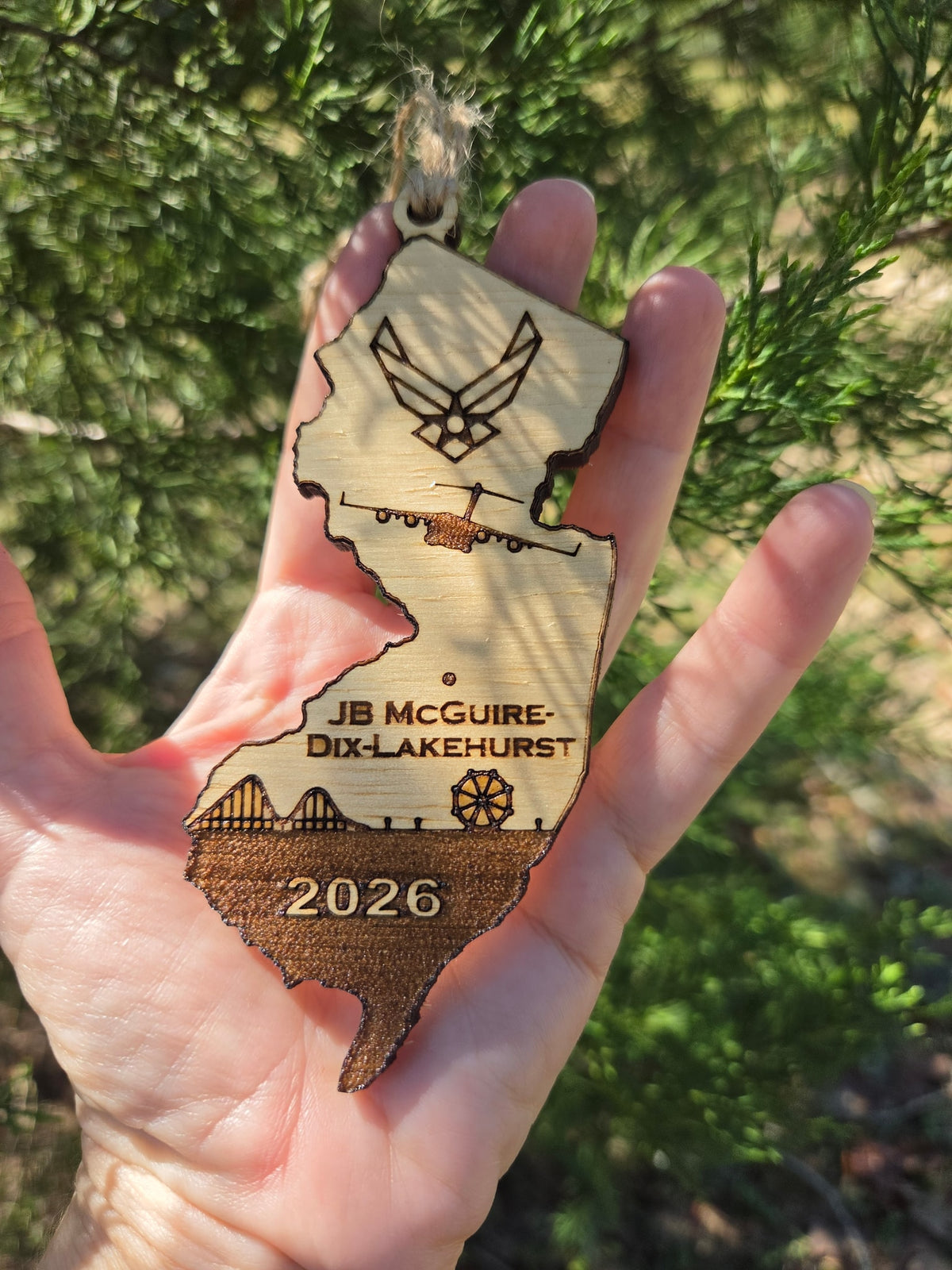 JB McGuire-Dix-Lakehurst ornament held in an open hand in dappled sun