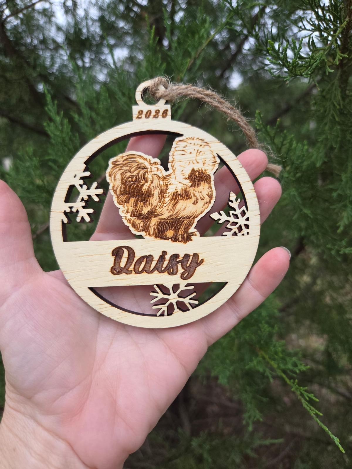 Silkie chicken and snowflakes ornament held in an open hand to show its size