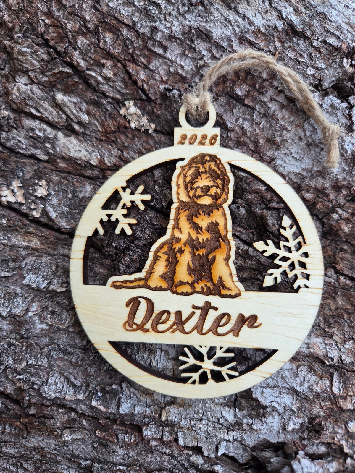 Wooden sitting doodle dog and snowflakes ornament, front with a sample name and year engraved, without its colored back
