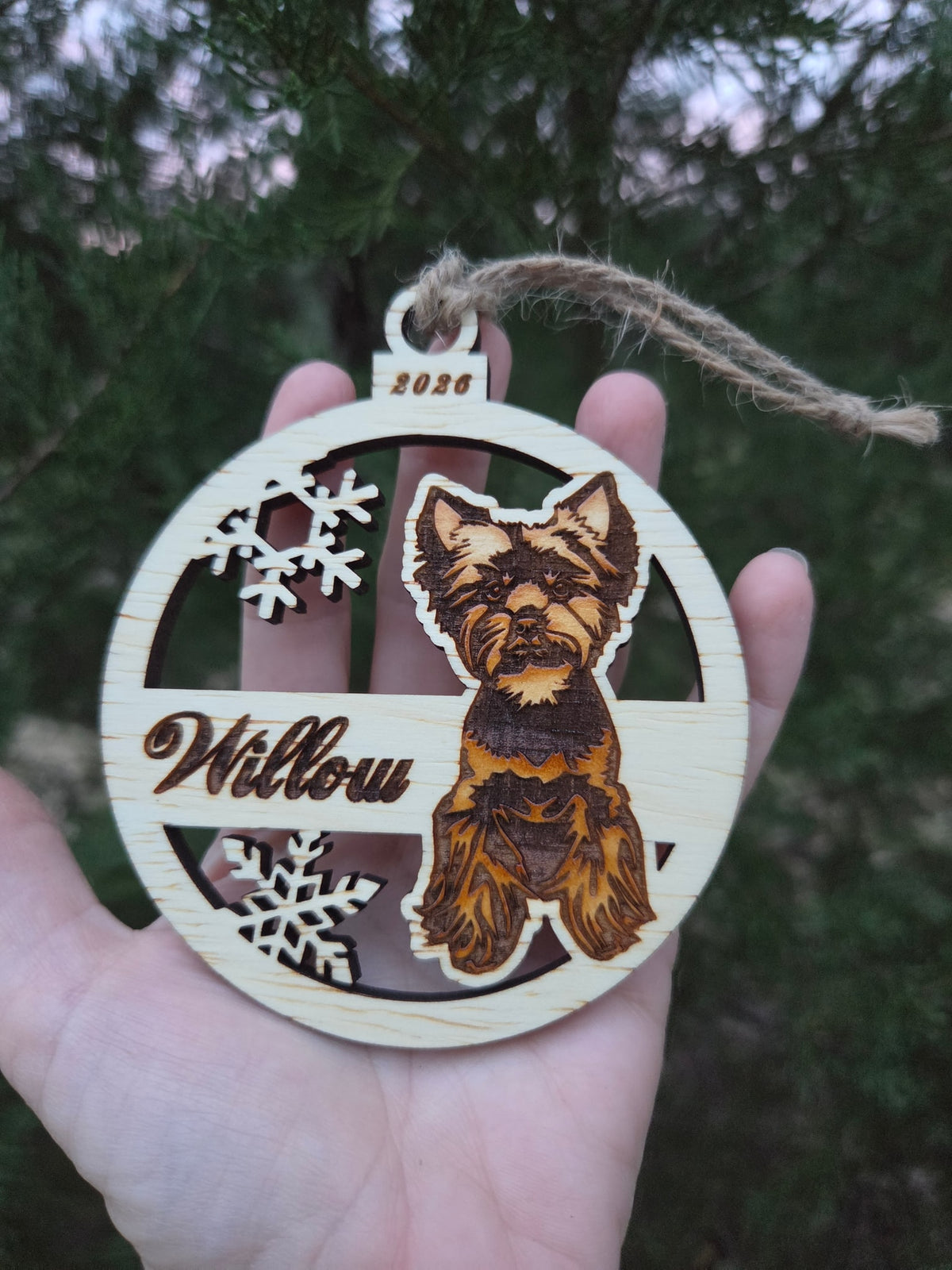 Sitting Yorkie ornament held in an open hand to show its size