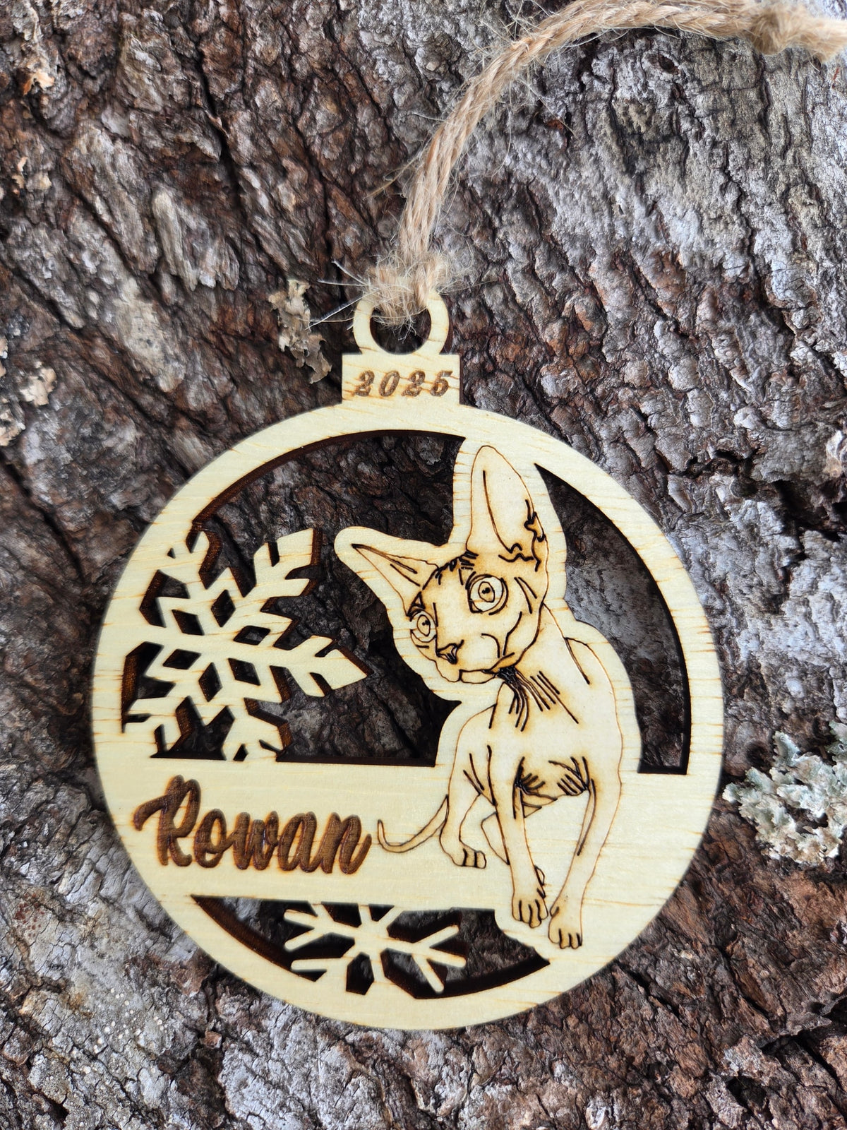Wooden Sphynx cat and snowflakes ornament, front layer with a sample name and year engraved, shown without its colored back