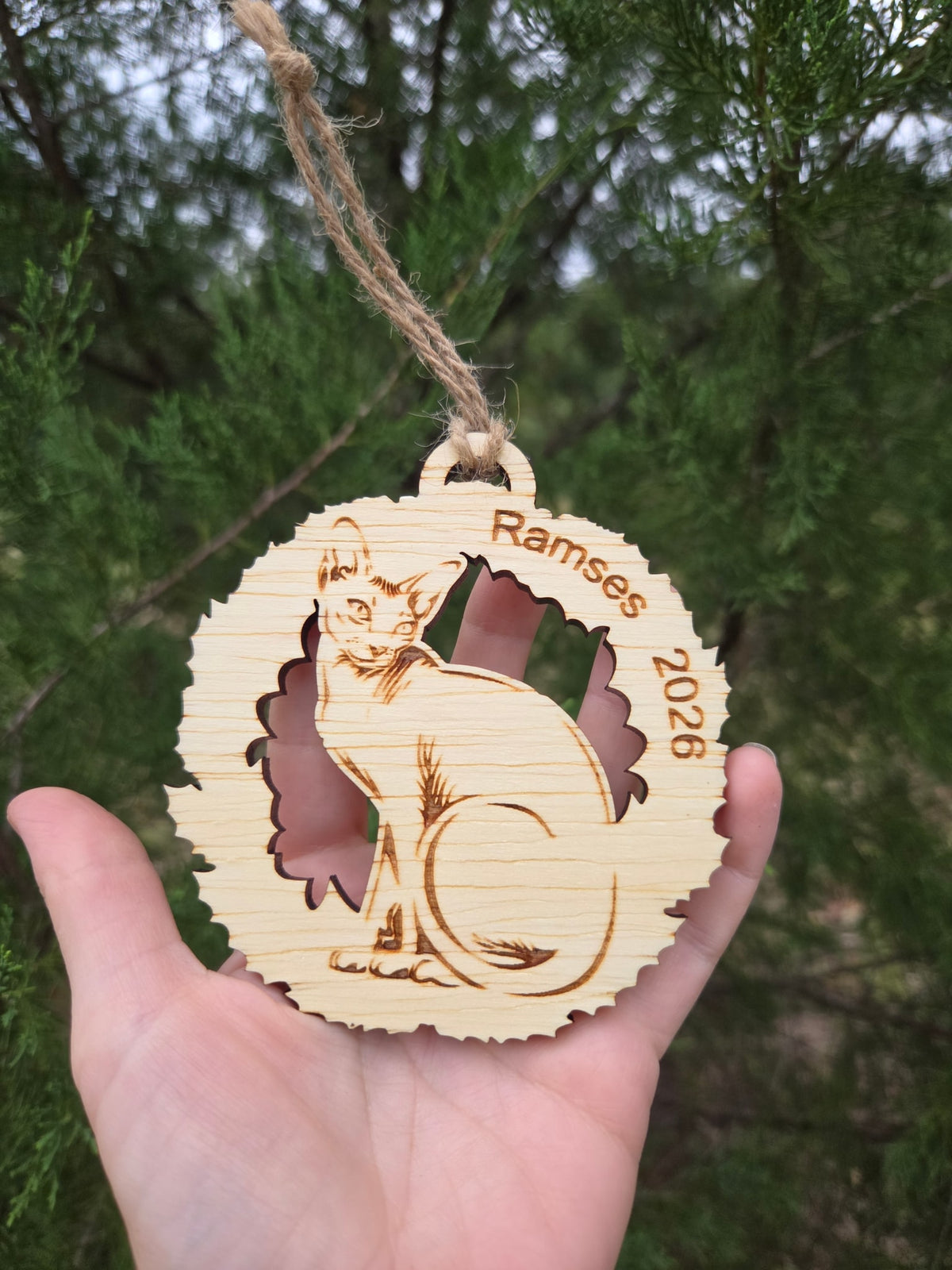Sphynx cat wreath ornament held in an open hand to show its size