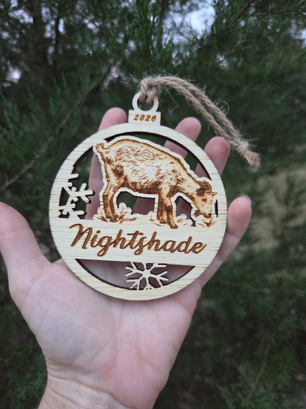 Standing goat ornament held in an open hand to show its size