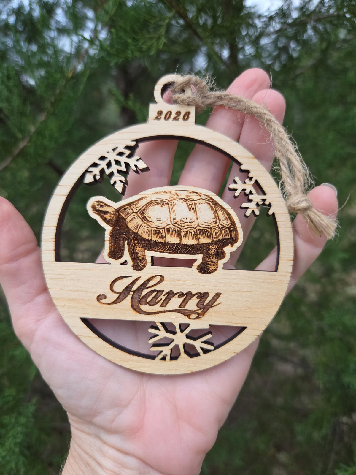 Tortoise and snowflakes ornament held in an open hand to show its size