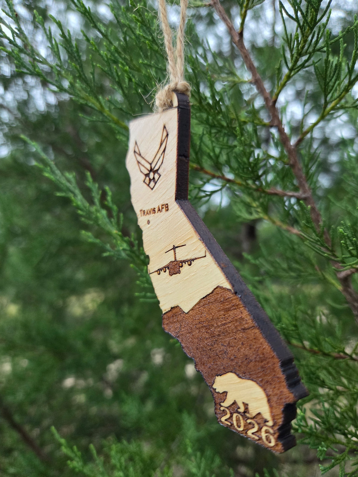 Side view of the Travis AFB ornament showing the thickness of the wood and its dark cut edge