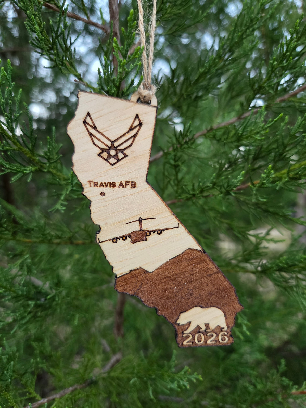 Travis AFB C-17 California ornament hanging on an evergreen branch